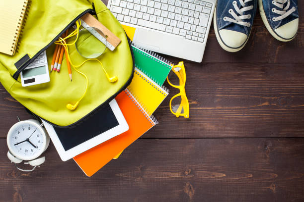 Back to school concept. Backpack with school supplies. Top view. Wooden background. Copy space.